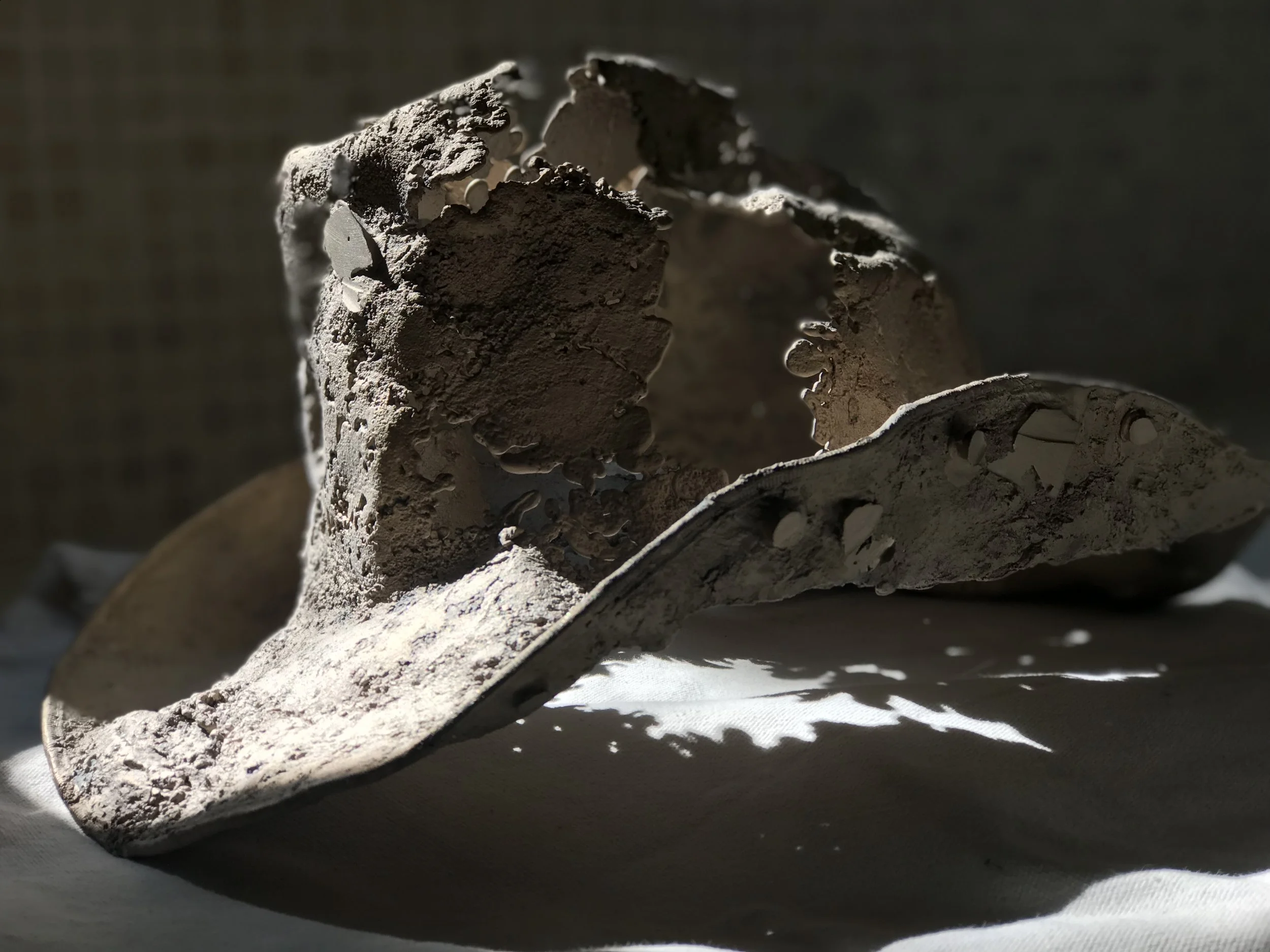 In the fall of 2018 I started this piece to add to my Heritage series of sculptures. As a teen, I shaped hats in my father's western wear store and I began to understand that old hats are reflections of their owners, that they keep a bit of the spirit of the person who wore them. When I start a piece I am often thinking about a specific individual and a challenge they're facing. While working on this piece I had a conversation with a friend about his career. This friend is very very passionate about his profession and has an admirable work ethic. His work situation has been frustrating for several years. There was not a way he could remedy the situation. In the end he turned challenging circumstances into a new opportunity. He took the leap and carved a new path. Initially, when I broke the piece out of the shell I was disappointed that there were so many spots that did not pour. The texture is exactly what I wanted, well worn and full of passion and character. A little frustrated but keeping an open mind, I set it on my utility room counter. I like to set pieces I am working on there so I can glance at them quickly as I go about my household tasks. This allows me to think and rethink my next step with the piece. I walked by it and glanced over quickly and it hit me, those patches that did not pour could resemble the new path that my friend carved. Is it possible this piece took on bit of the spirit of my friend and his circumstances? The next step with this piece is to do the metal chasing. Once the metal work is done I need to make a decision regarding the cool spots. Do I want to patch the cool spots or leave it as is. I will have to ponder that. Below is a list of the other things that I was thinking about as I shaped this piece.