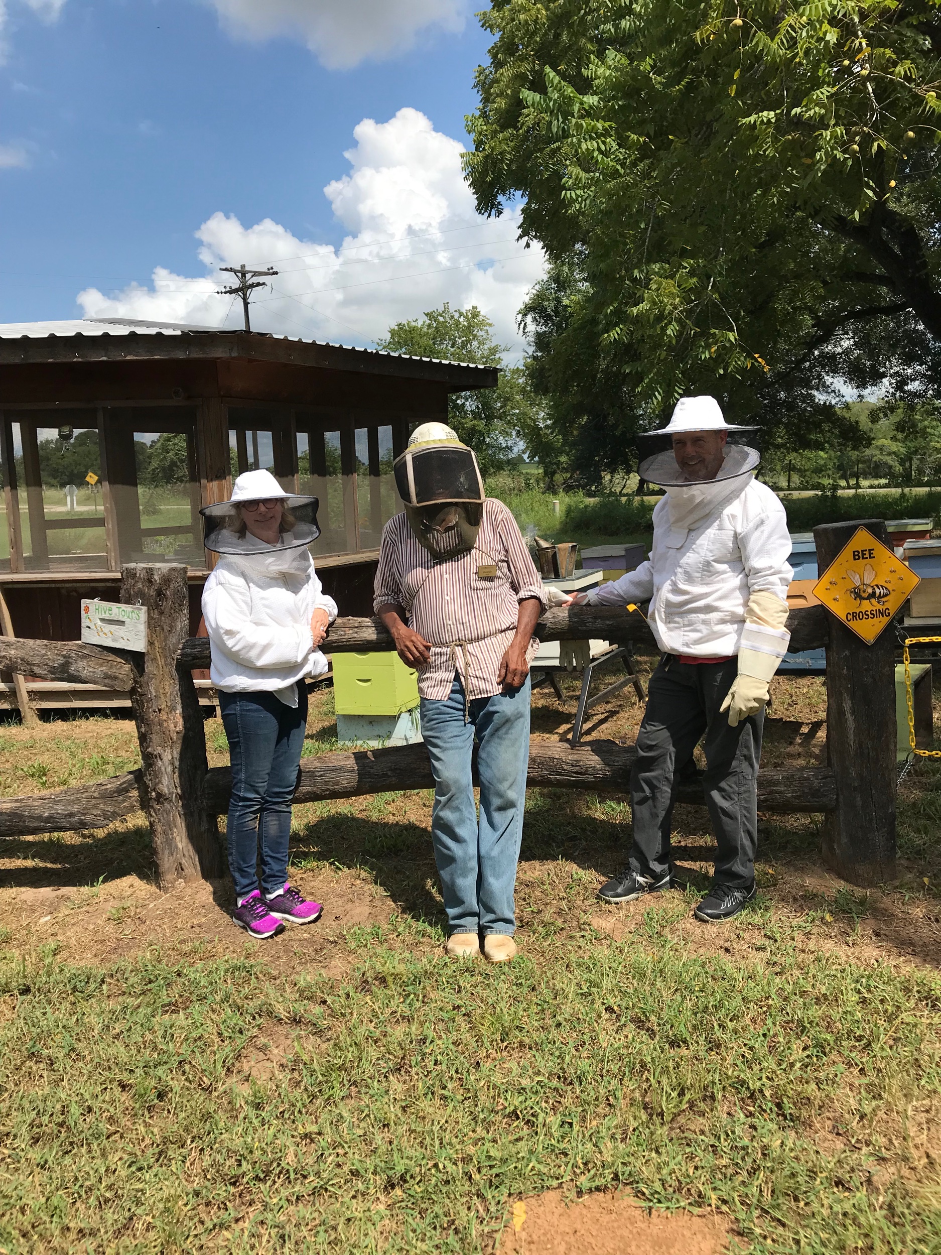 You need to wear long sleeves, loose jeans, and closed-toe shoes. They provide the bee nets/hats and jackets. We are posing in front of some bee boxes and trying to let you see the smoke can behind us. Roosevelt really wanted the smoke to show in th…