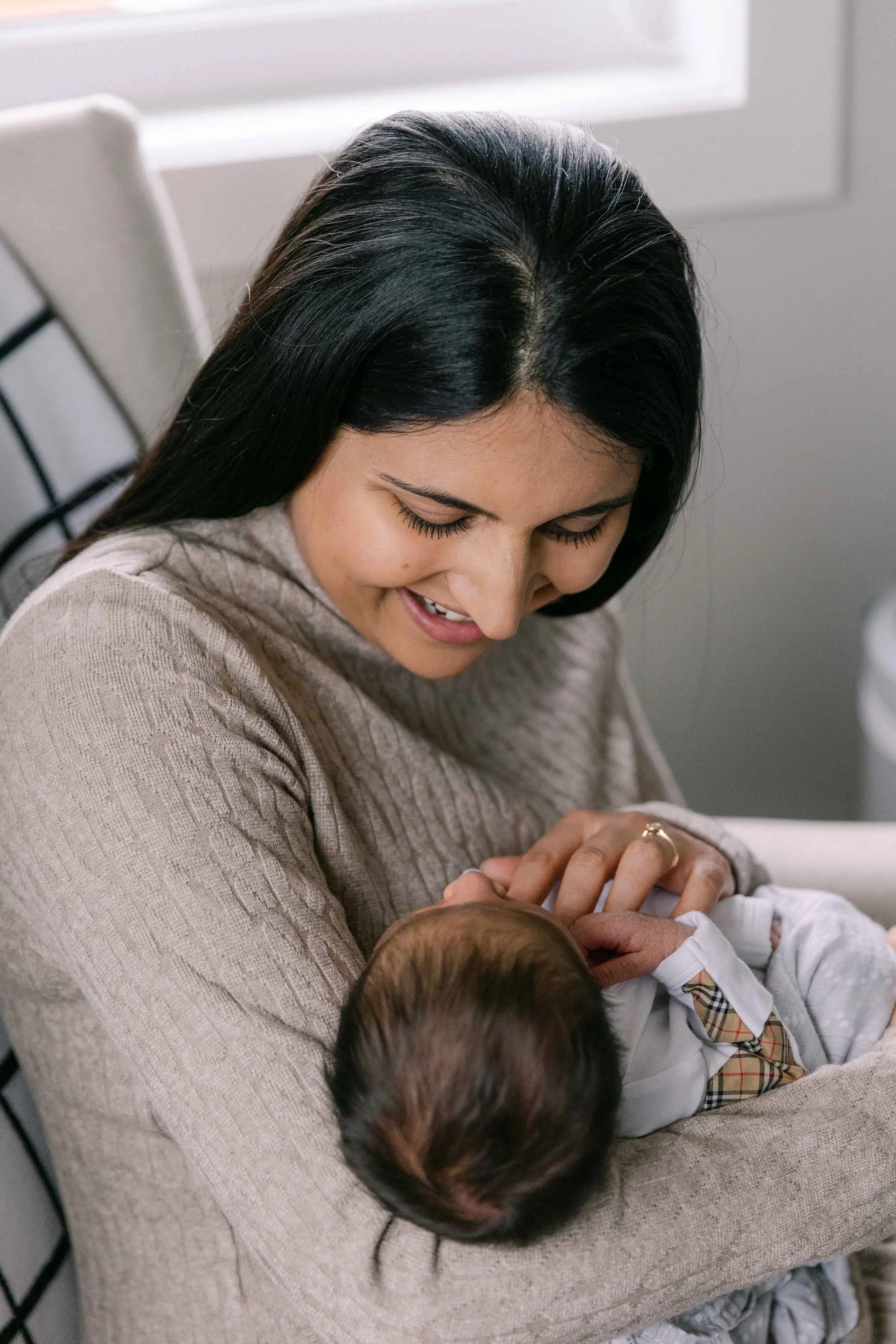 Mother and baby newborn lifestyle shoot, wearing cream, white and black neutrals, indian mother and son