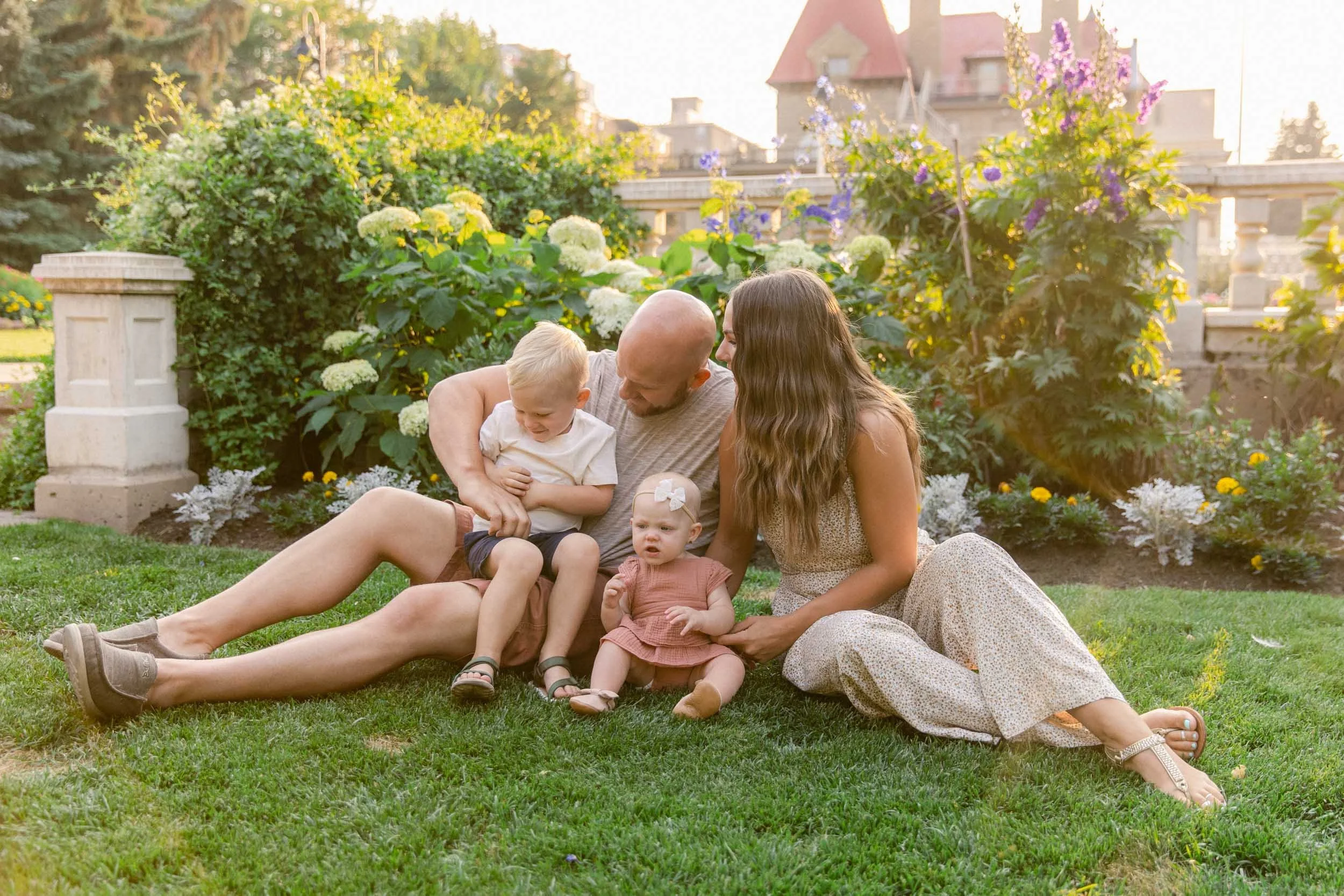 A family photo shoot at the Beaulieu Gardens at Lougheed House, sitting in front of flowers in dusty rose, creams and miniature floral patterns