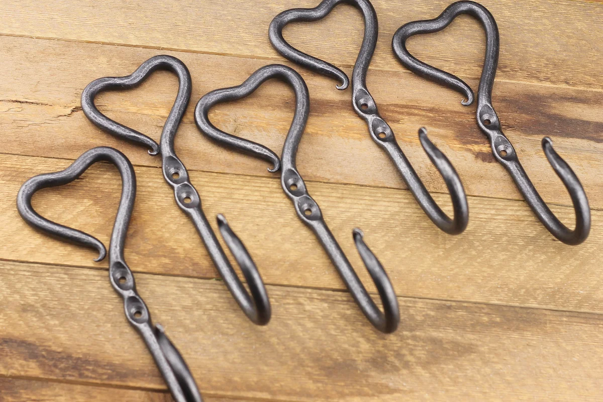 Set of forged iron hooks on a rustic tabletop