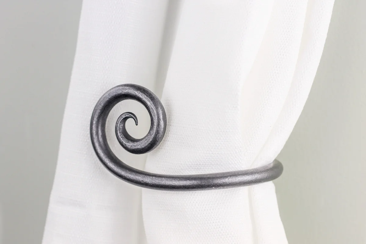 Scroll style iron curtain tie back hook.