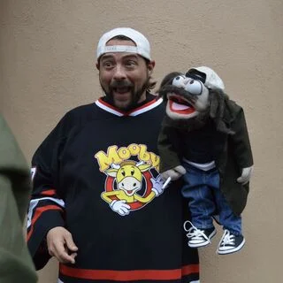 Kevin Smith holding tribute Silent Bob puppet.