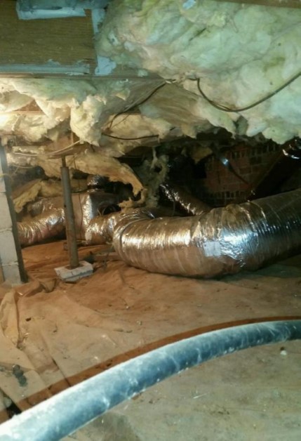 Debris and fallen insulation and ductwork in crawl space