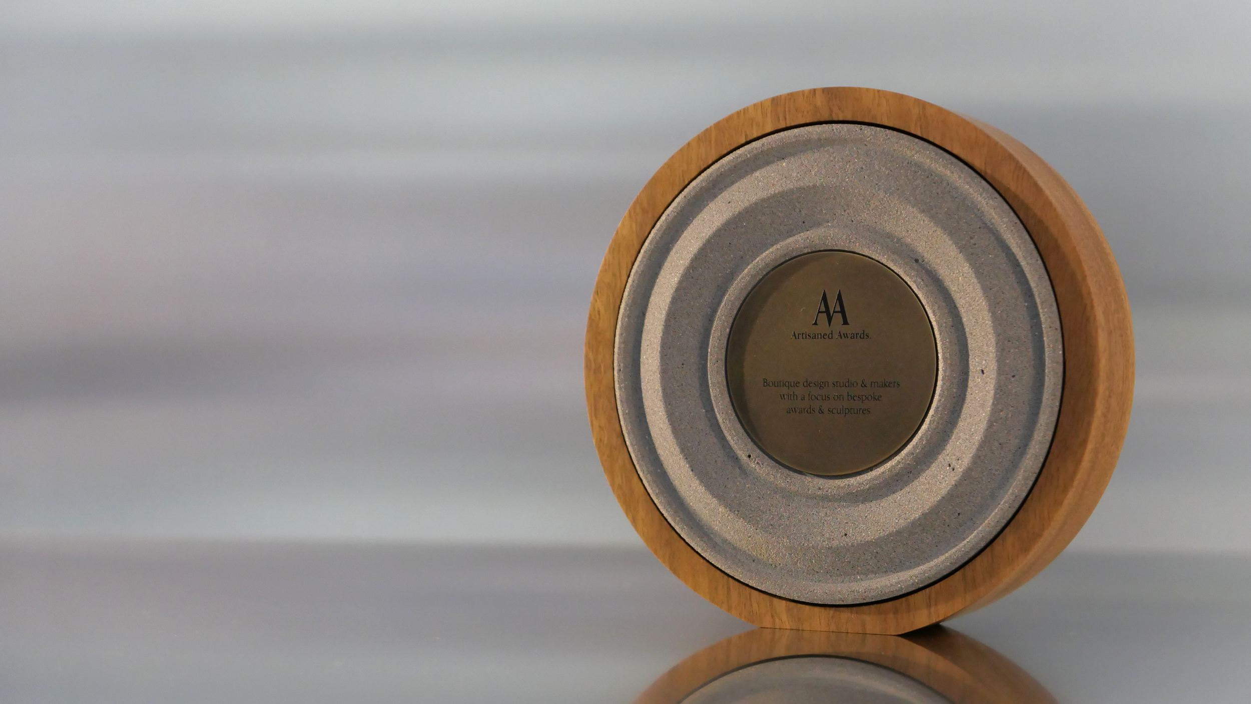 Amphi core design, light hardwood surround, warm grey core finish & blackened brass plaque.