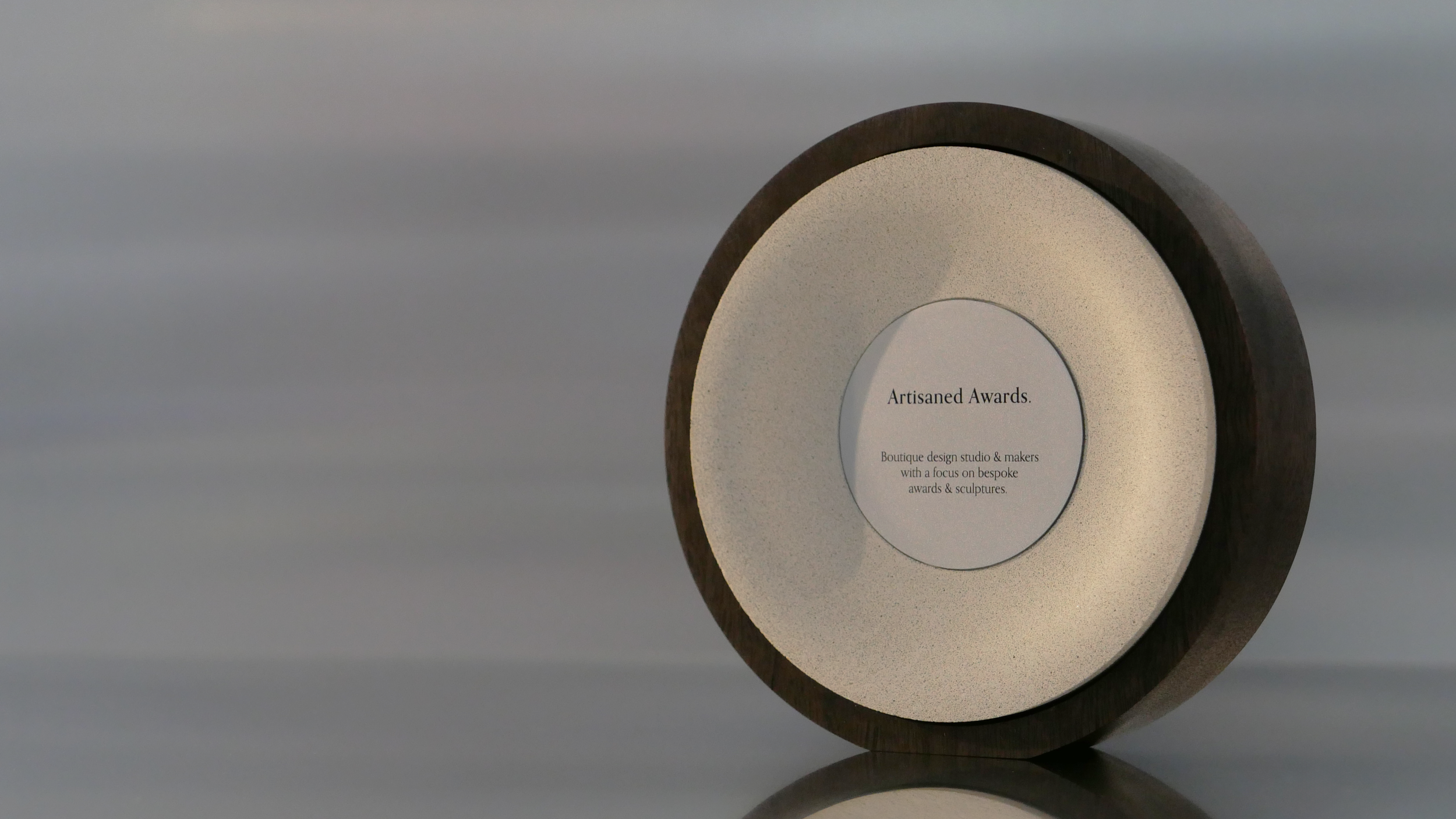 Arc core design, dark hardwood surround, beige core finish & bead blasted aluminium plaque.