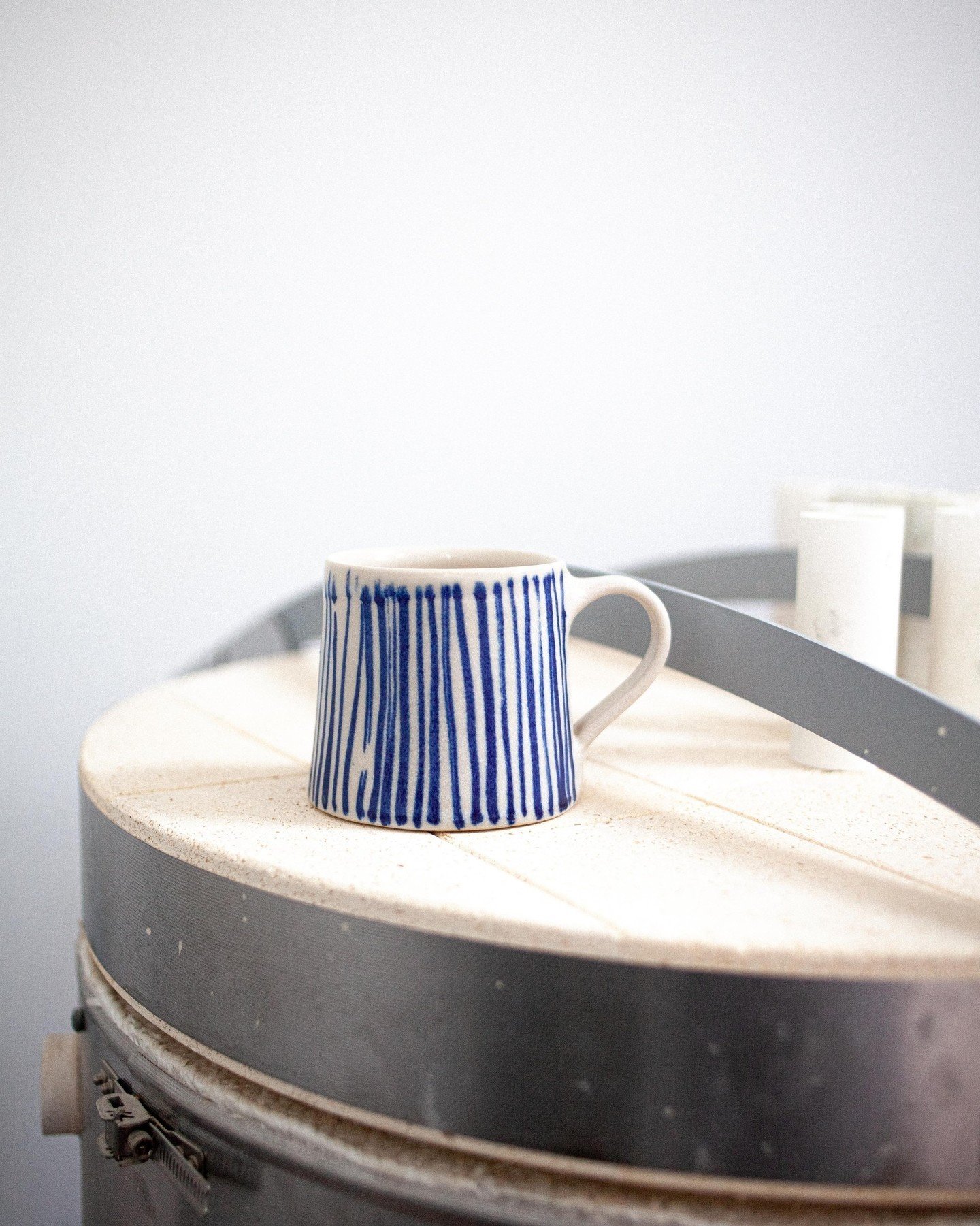 A tall mug in Cobalt Line, fresh from the kiln, still slightly warm to touch. This one takes the longest to paint but might just be my favourite. ⁠
⁠
Available Wednesday 1st May, 7pm 💙⁠
⁠
#eotceramics #ceramics #handmadeceramics #pottery #studiopott