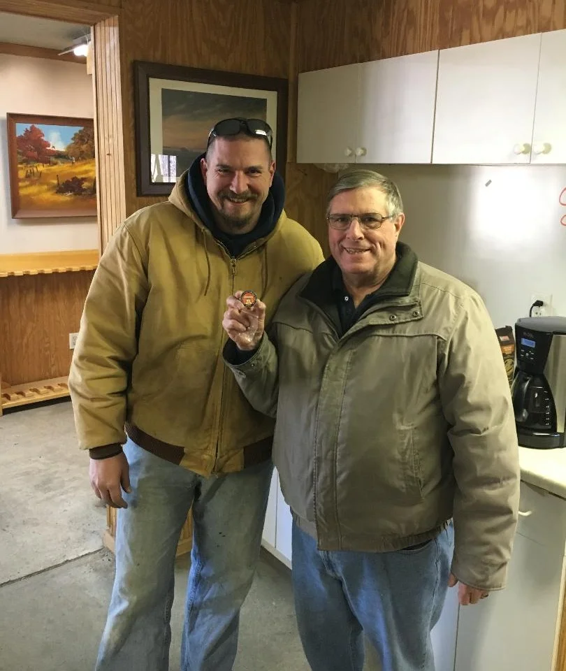 Bruce Krapf showing his pin won for a perfect round of skeet along side his son, mike.