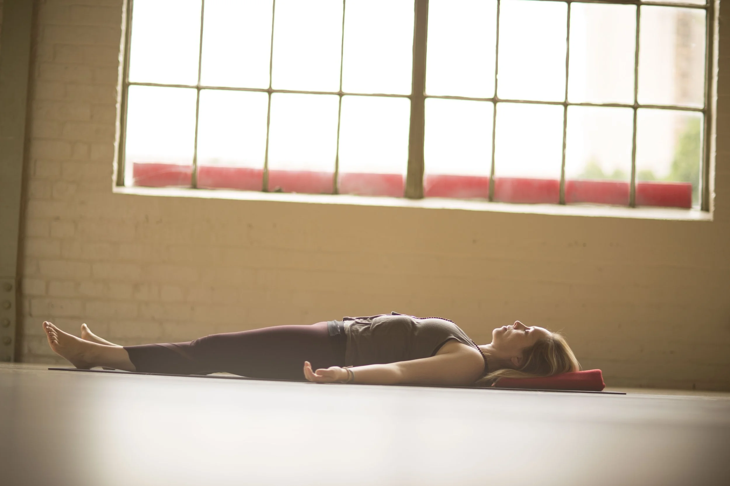 Woman lying on the floor in the yoga pose corpse pose