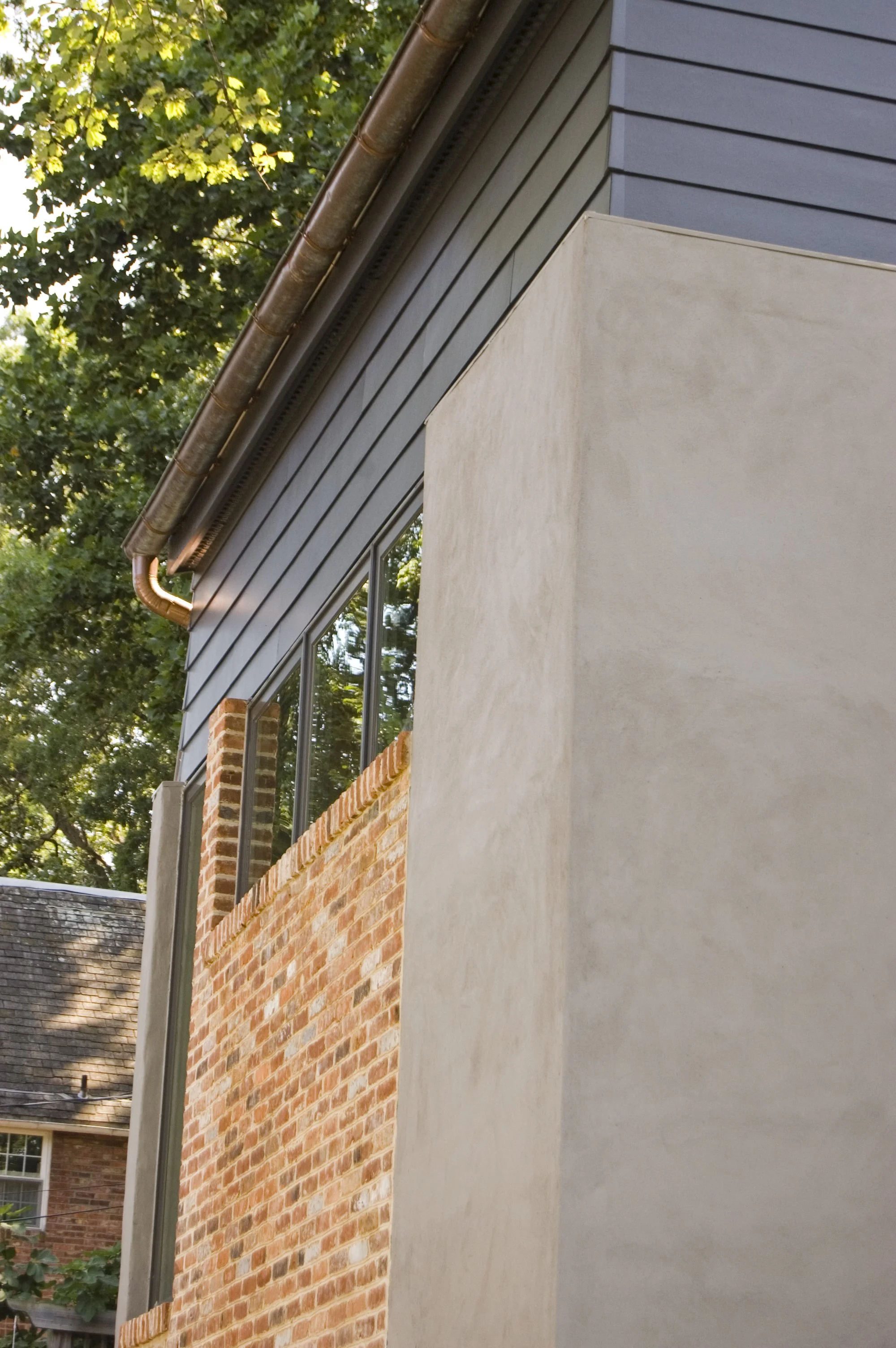 ADDITION WALL DETAIL OF REPURPOSED BRICKS AND PARGED CEMENT 
