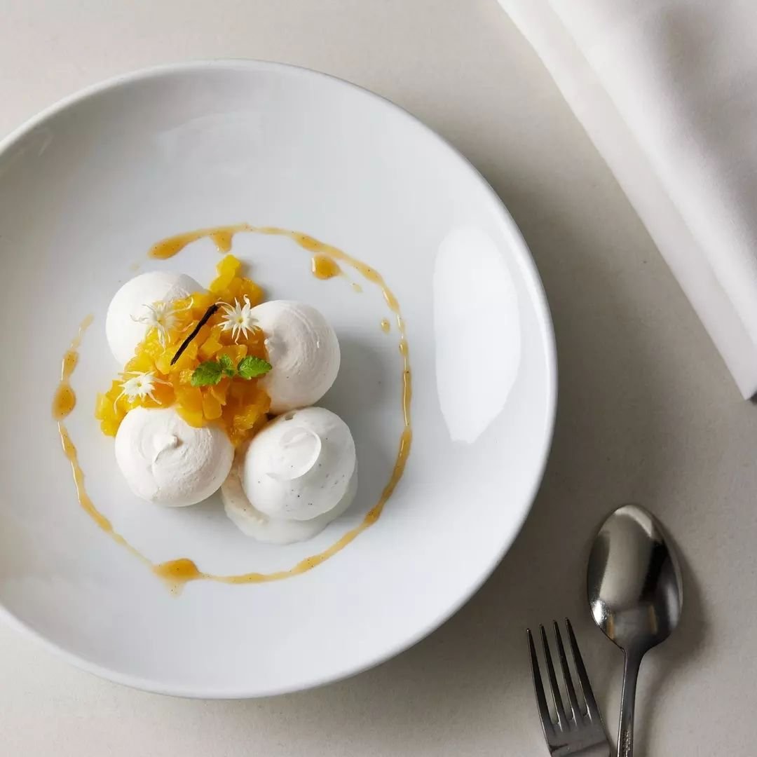 Indulge in our Mango Pavlova. Each bite is a burst of tropical bliss, with layers of tangy finger lime, lime curd, and creme chantilly, topped off with a refreshing guava sorbet.