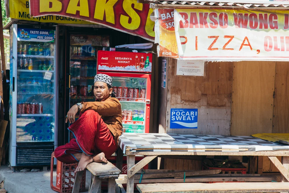 Local relaxing by his store front.