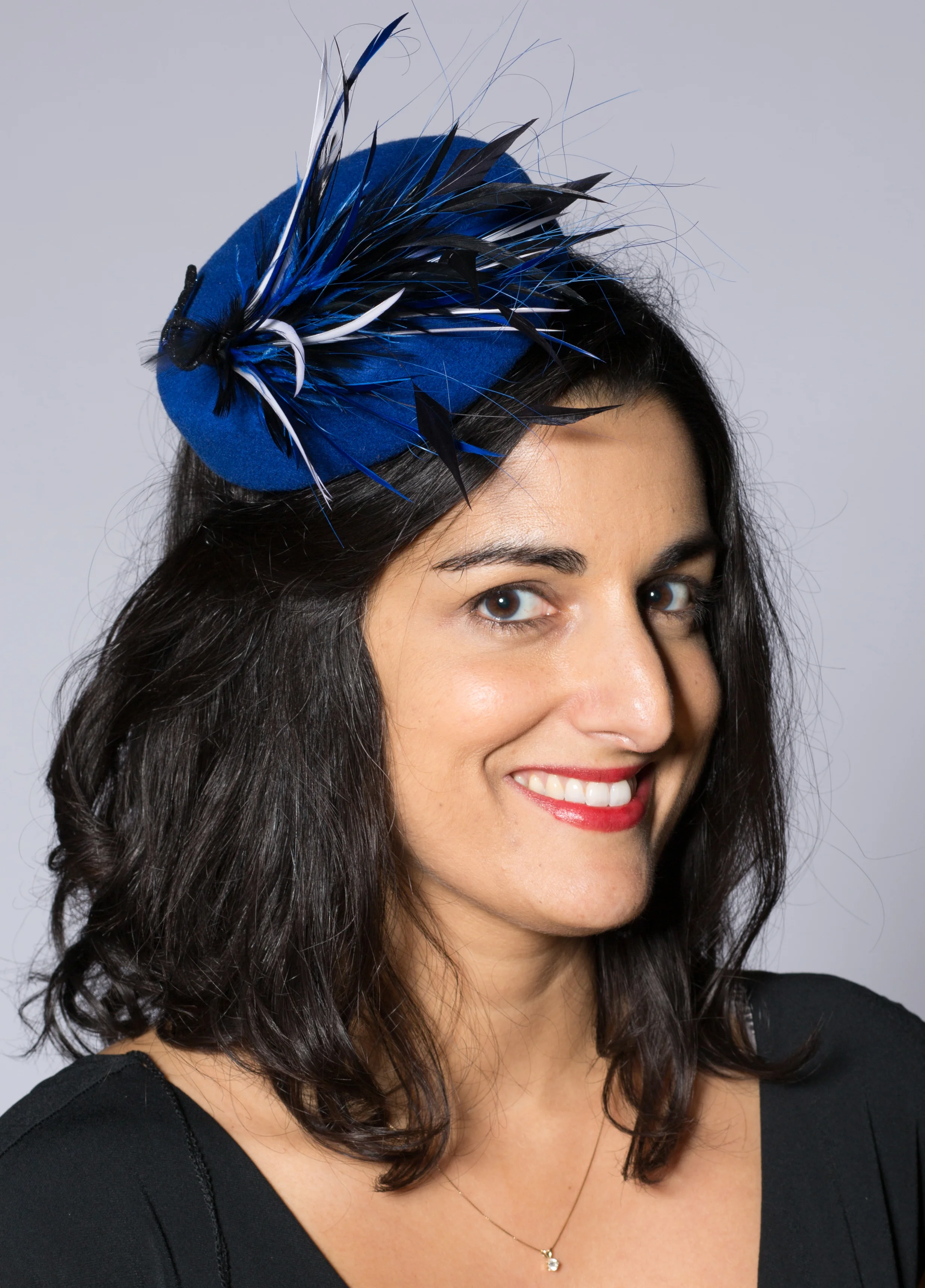 Blue pillbox with black, white and blue feathers