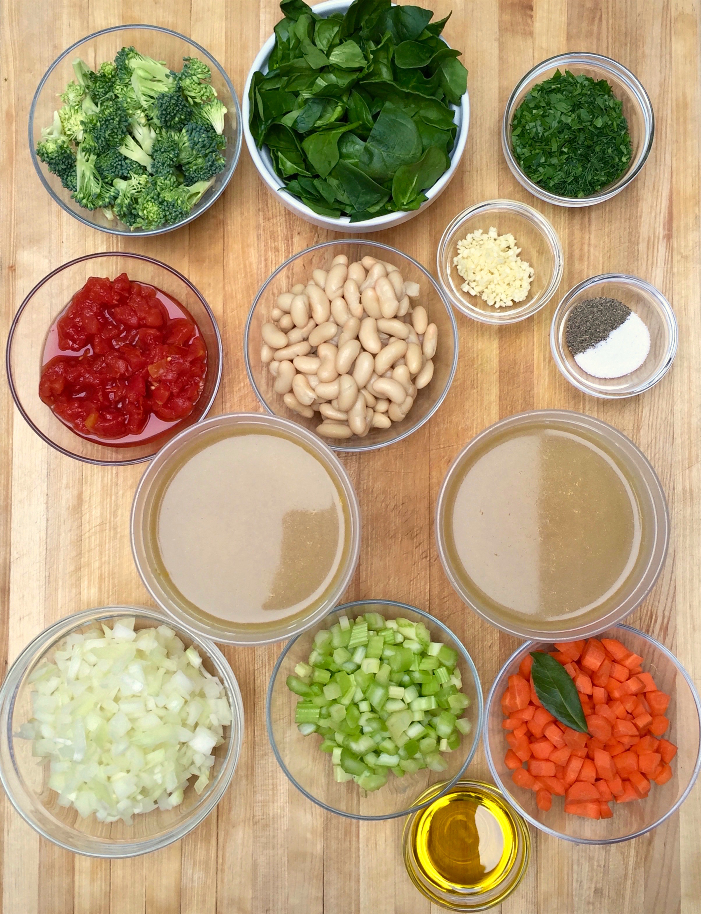 The cast of characters, in the order of their appearance: (front row) 3 tablespoons olive oil; the Mirepoix - 2 cups onions, 1 cup celery and 1 cup carrots, 1 bay leaf; (second row) 2 quarts chicken stock; (third row) 1 cup diced tomatoes with their juices); 1 cup cannellini beans; 1 tablespoons kosher salt & 1 teaspoon black pepper; 2 cloves minced garlic ; (fourth row) 1 1/2 cups broccoli florets; 2 heaping cups ( 2 oz) spinach; 6 tablespoons mixed chopped herbs.