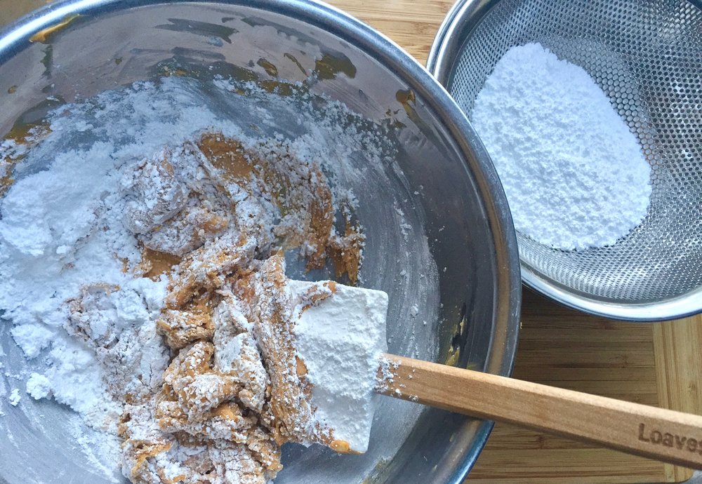 Mixing confectioners sugar into the peanut butter mixture.