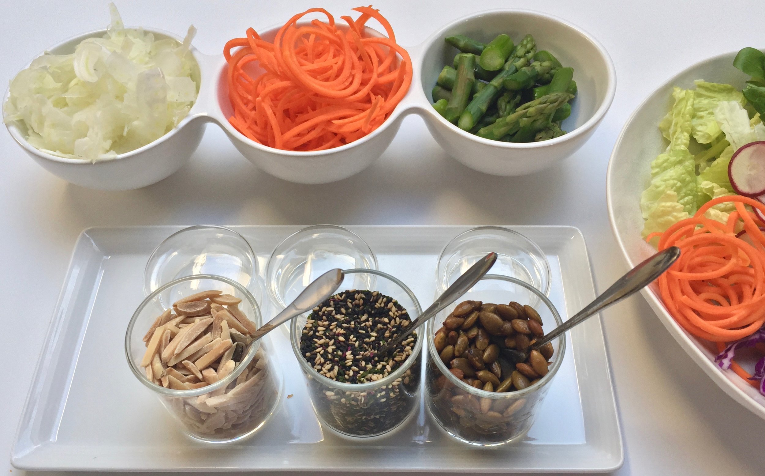 It's a Buddha Bowl Bar! Some components to add to your bowl - raw shaved fennel, pickled carrot spaghetti and blanched asparagus. To add some crunch we offered toasted sliced almonds, black & white sesame seeds with sea vegetables and toasted pumpkin seeds.