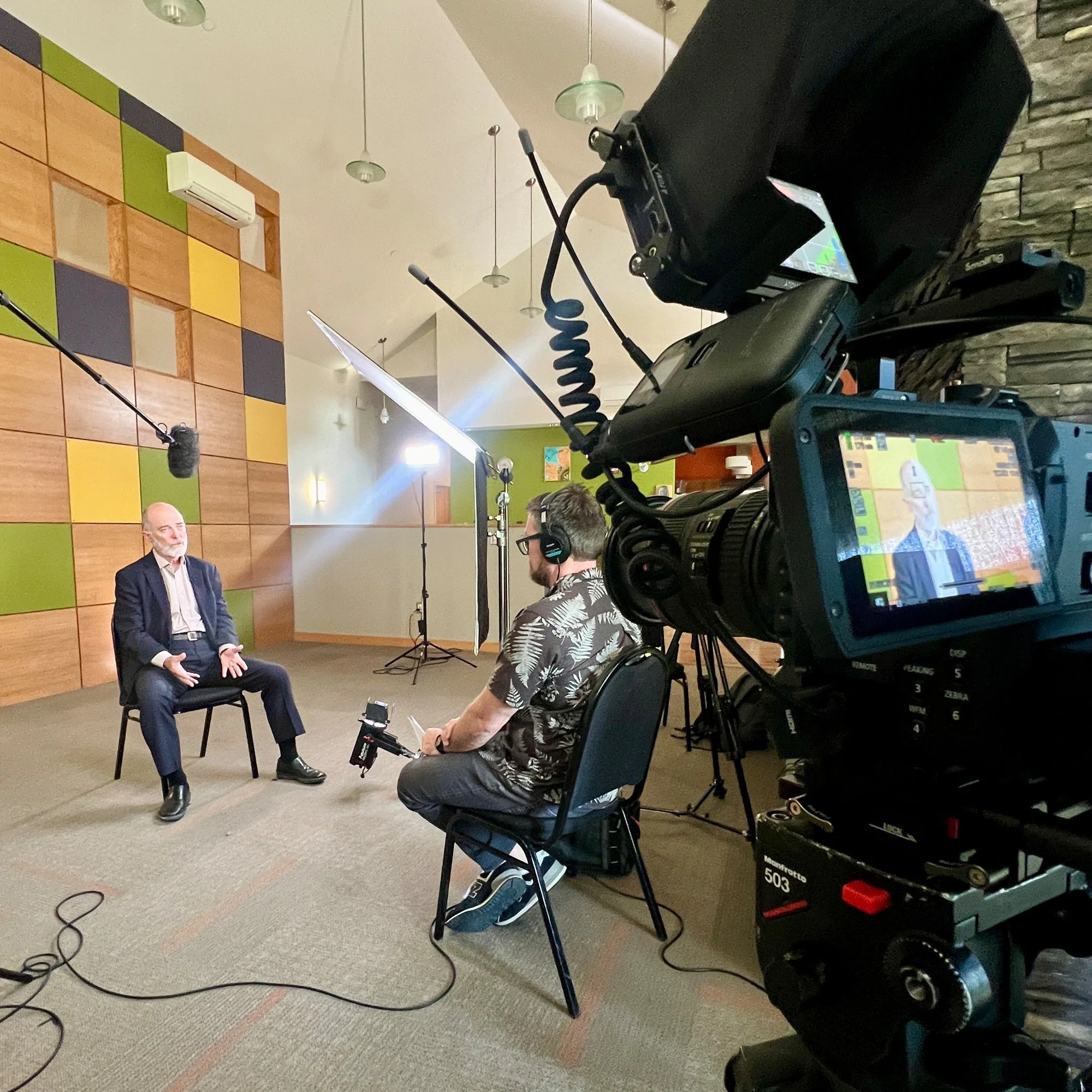 video camera in foreground, interviewer interviews middle aged man, minneapolis videographer