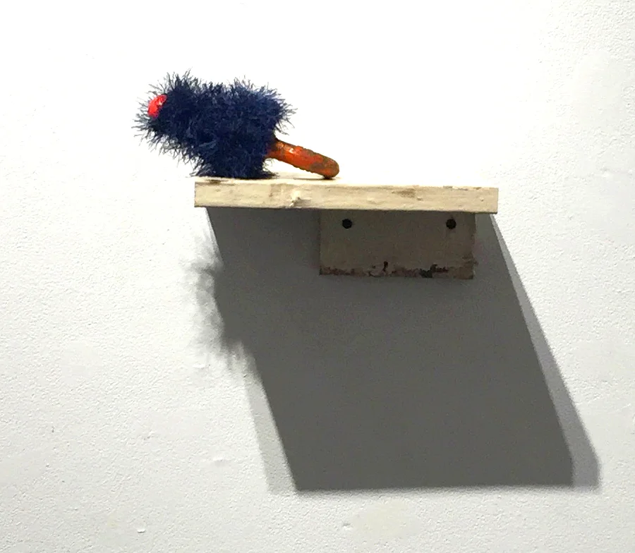 merkin 2015, baby cow nursing nipple, found iron ring, shelf made from found wood, yarn A humorous reference to a human hair wig worn over the pubic area. 