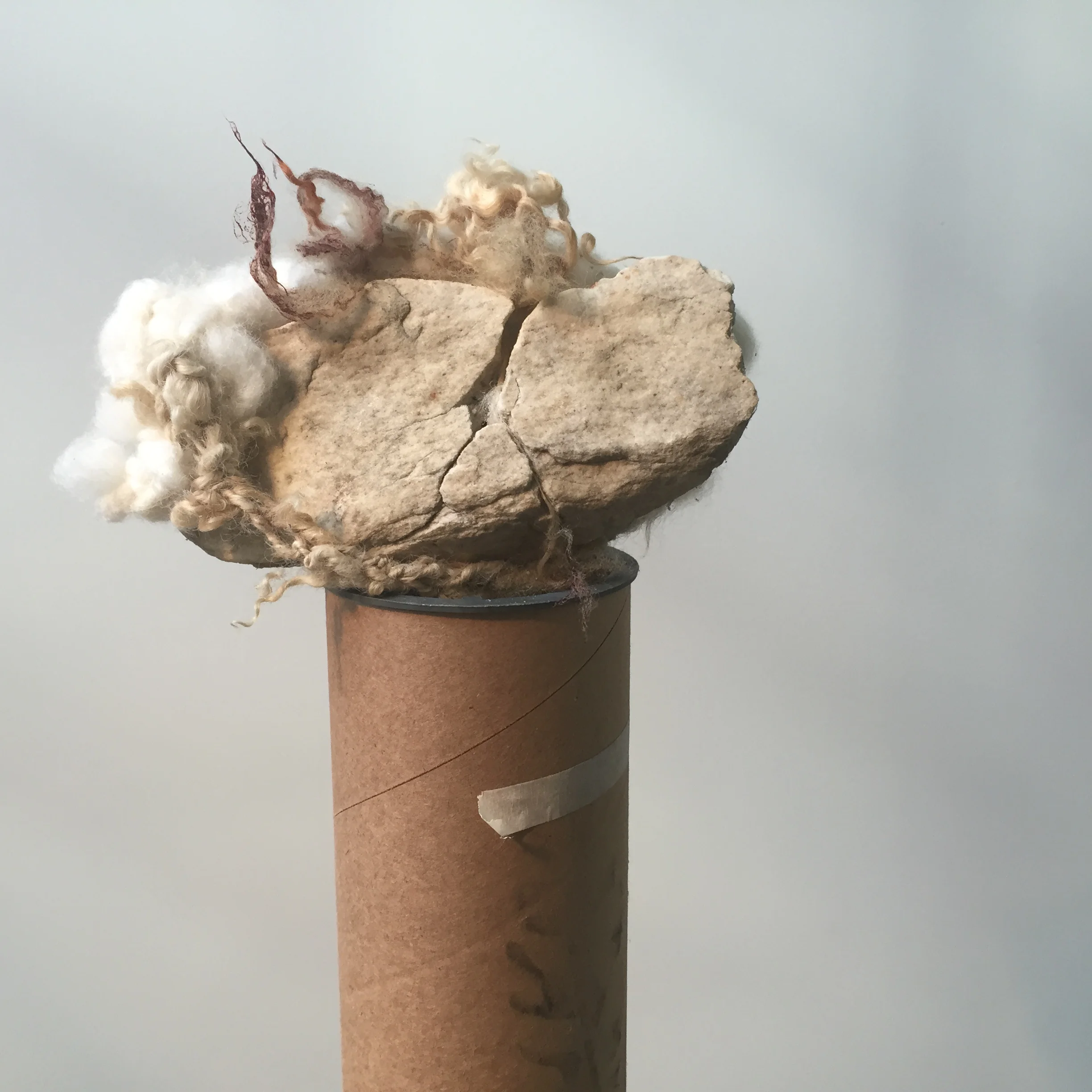  slit&nbsp;  2015 &nbsp;found rock, handspun and dyed wool yarn, cardboard tube.&nbsp;  68 x 7.5 x 4 inches     An artist residency at MASS MoCA/Assets for Artists inspired me to hand dye and spin my own yarn as a way to add layers of meaning to the 
