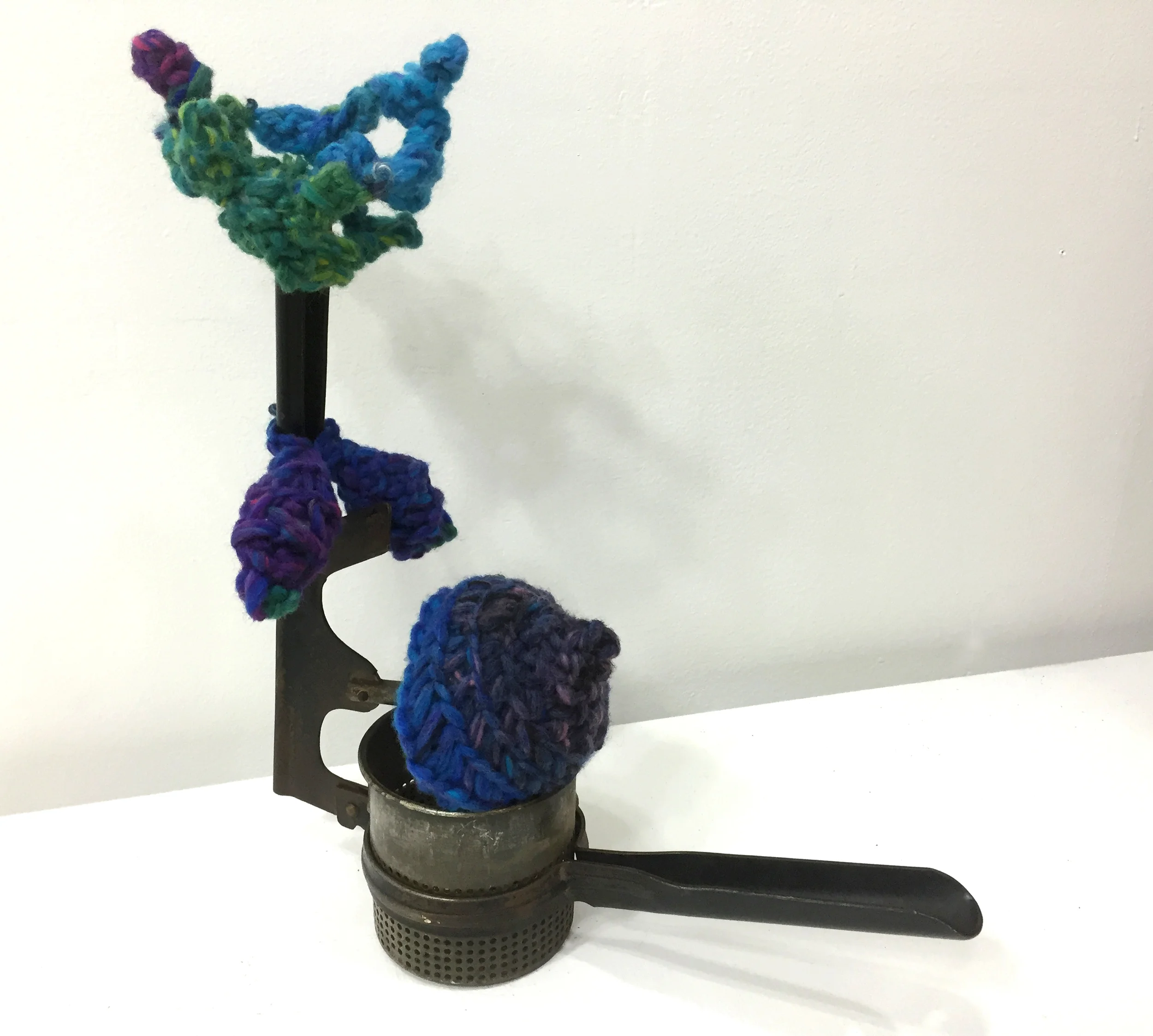 fertility sculpture with crown of children potato masher, yarn homage to Martha Rosler.