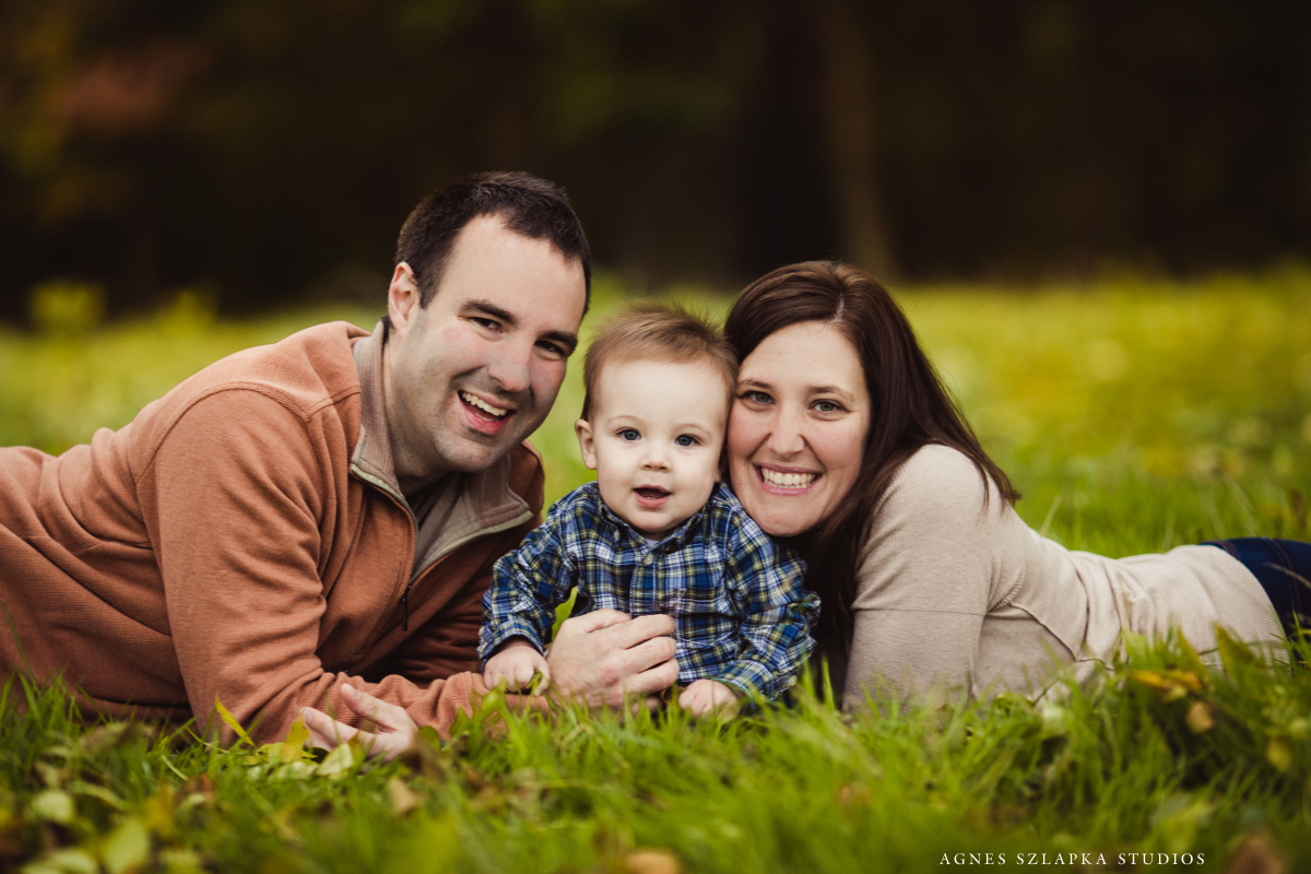 family of three laying on grass-9 month old baby boy | cleveland, ohio portrait photographer