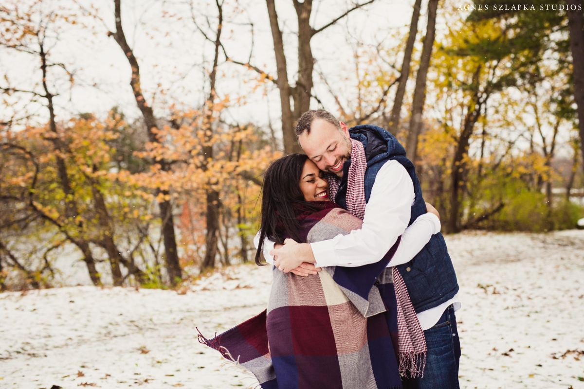 mom and dad squeezing tight to stay warm on snowy day | cleveland, ohio family portraits