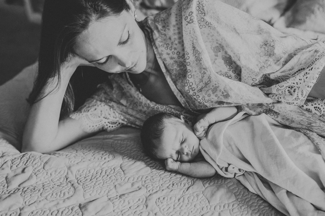 mom on bed with newborn baby girl | cleveland, ohio family photography