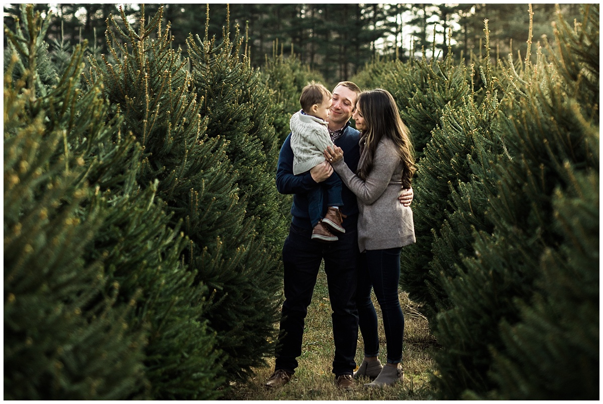 family of three standing among pine trees | cleveland lifestyle photographer