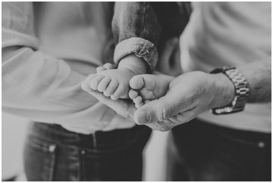 dad holding tiny baby feet of daughter | cleveland, OH lifestyle newborn photographer