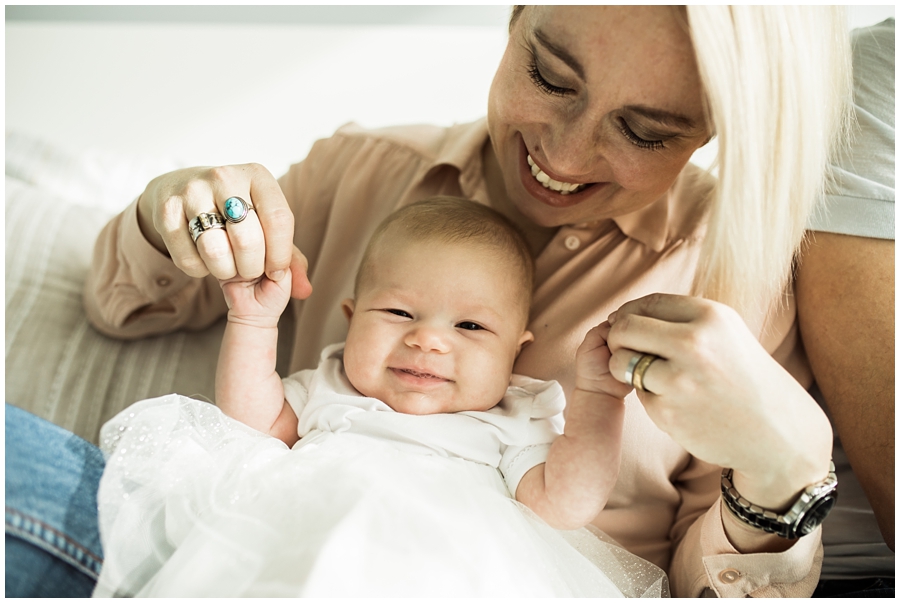 mom and baby daughter relaxing and smiling on bed | cleveland, OH baby photographer