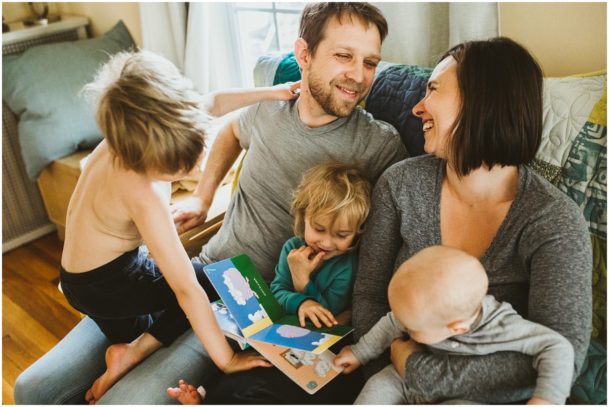 family of five reading a book on sofa | cleveland, OH newborn photographer