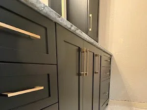Black custom bathroom vanity with gold hardware.