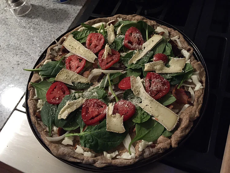 Spinach, tomato, onion and brie pizza.