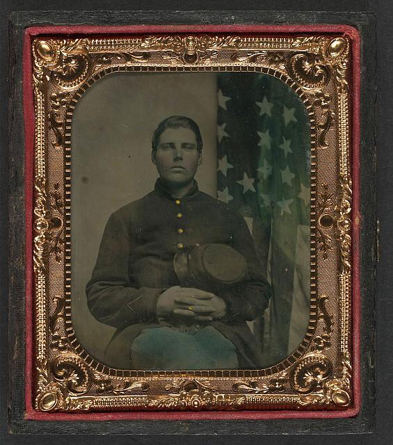 Soldier in Uniform with Forage Cap in Front of American Flag | Circa 1861-1865