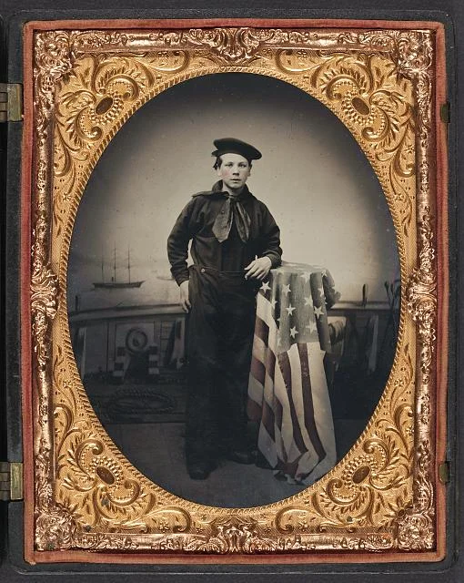Young Sailor in Union Uniform with American Flag in Front of Backdrop Showing Naval Scene | Circa 1861-1865