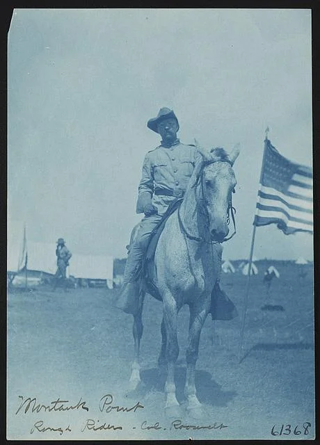 Teddy Roosevelt Wearing Rough Rider Uniform and Sitting on a Horse with an American Flag | Circa 1898