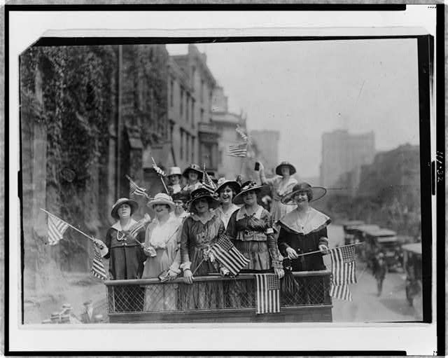Group of Women Standing on Top of Vehicle Waving Flags in New York City | Circa 1907