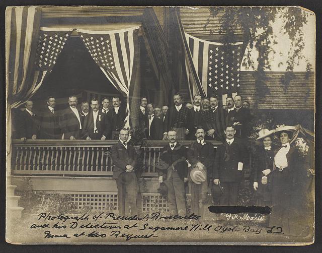 President Roosevelt and His Detectives at Sagamore Hill Posing on a Porch with Flags | Circa 1902