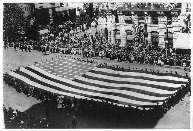 Huge Flag Being Carried by a Large Group of Men in a GAR Parade in Washington D.C. | Circa 1915