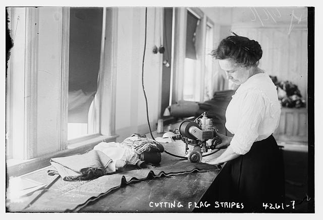 Woman Cutting Stripes for American Flags with Machinery at the Brooklyn Navy Yard | Circa 1917