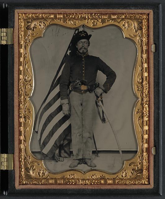 Soldier in Union Cavalry Uniform with Colt Dragon Revolver and Sword in Front of American Flag | Circa 1861-1865