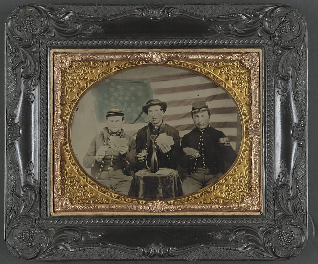 Three Soldiers Playing Cards, Smoking, and Drinking in Front of the American Flag | Circa 1861-1865