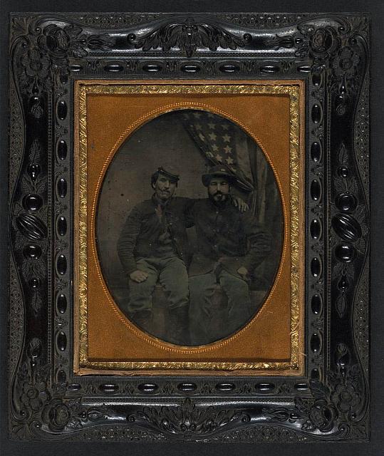 Two Soldiers in Union Uniform with Cigars in Mouths in Front of American Flag, One Being in a 6th Army of the Potomac Forage Hat | Circa 1861-1865