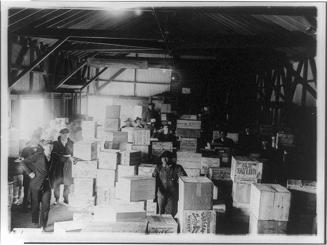 Men Standing in Warehouse with Cases of Confiscated Liquor | Circa 1921