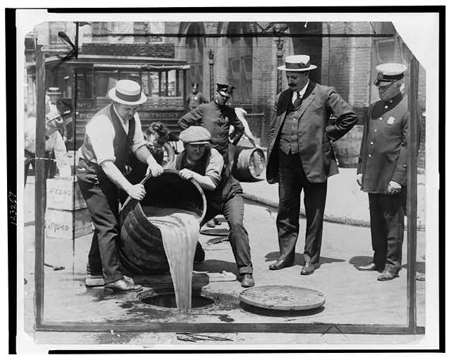 New York City Deputy Police Commissioner, John A. Leach, Watching Agents Pour Liquor into Sewer Following a Raid During the Height of Prohibition | Circa 1921