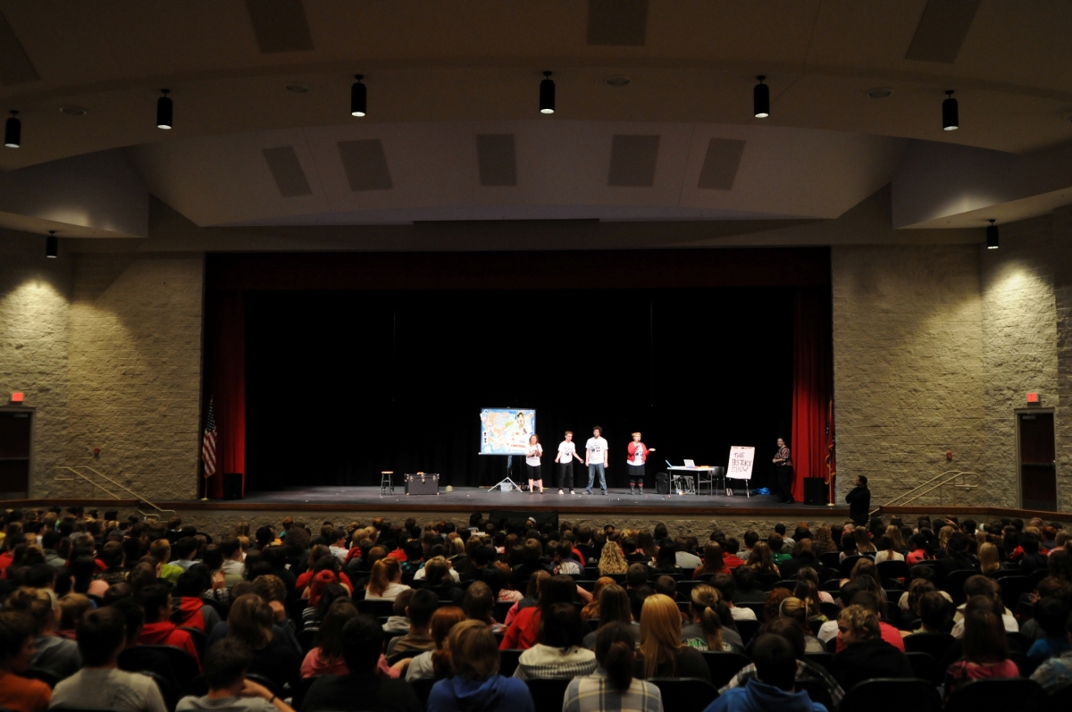 A full auditorium of high school students enjoy TheatreSquared's touring production of The History Show (2012).