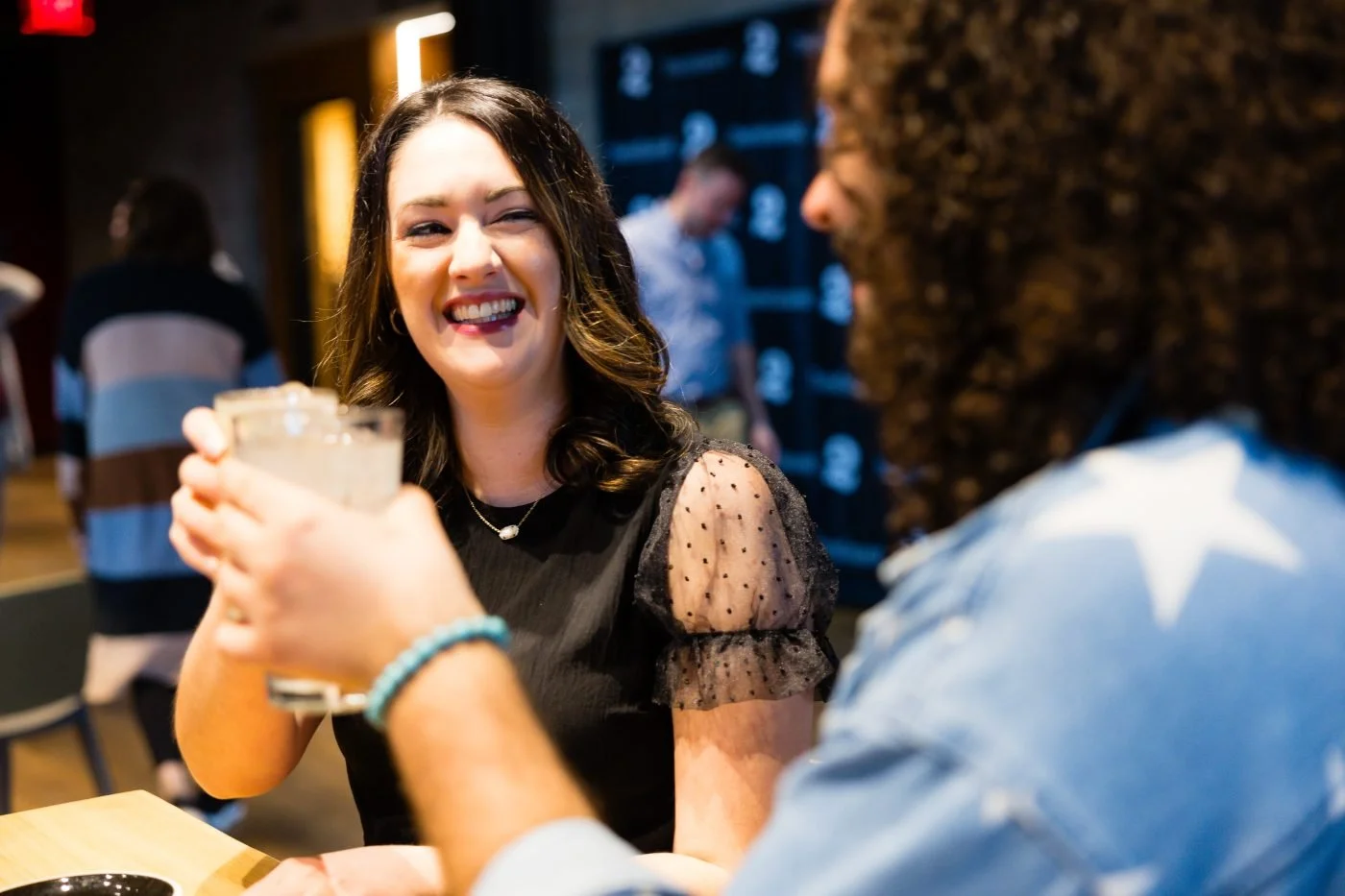 Two patrons raising a glass together in The Commons