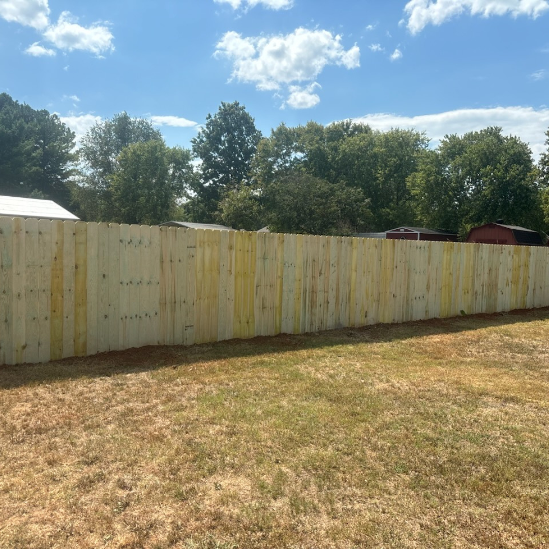 Dog-eared wood privacy fence bordering a backyard in Murfreesboro, TN — K & C Fence Company