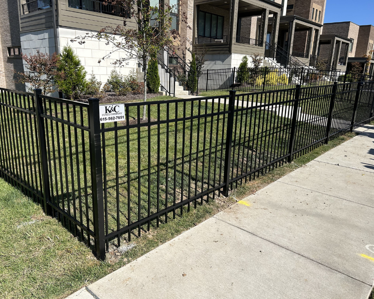 Black aluminum ornamental fence bordering a sidewalk and lawn installed by K&C Fence in Franklin, Tennessee for safety and curb appeal.