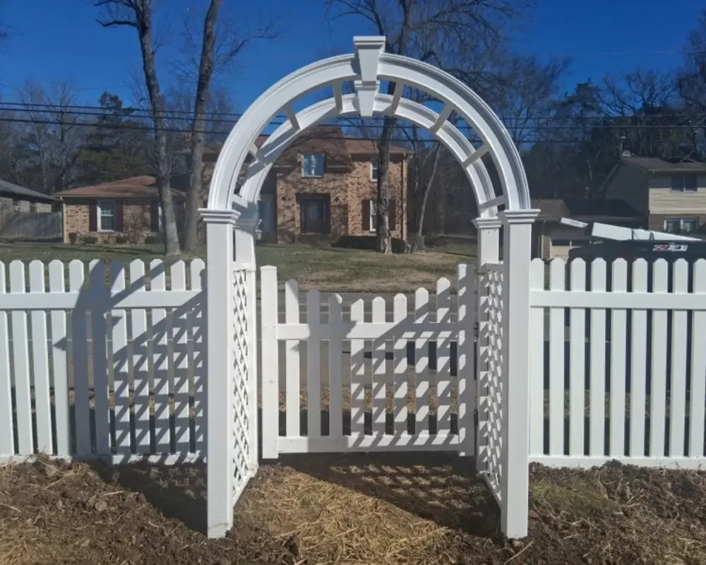 White Vinyl Picket Gate Beneath a Decorative Arbor with Lattice Sides
